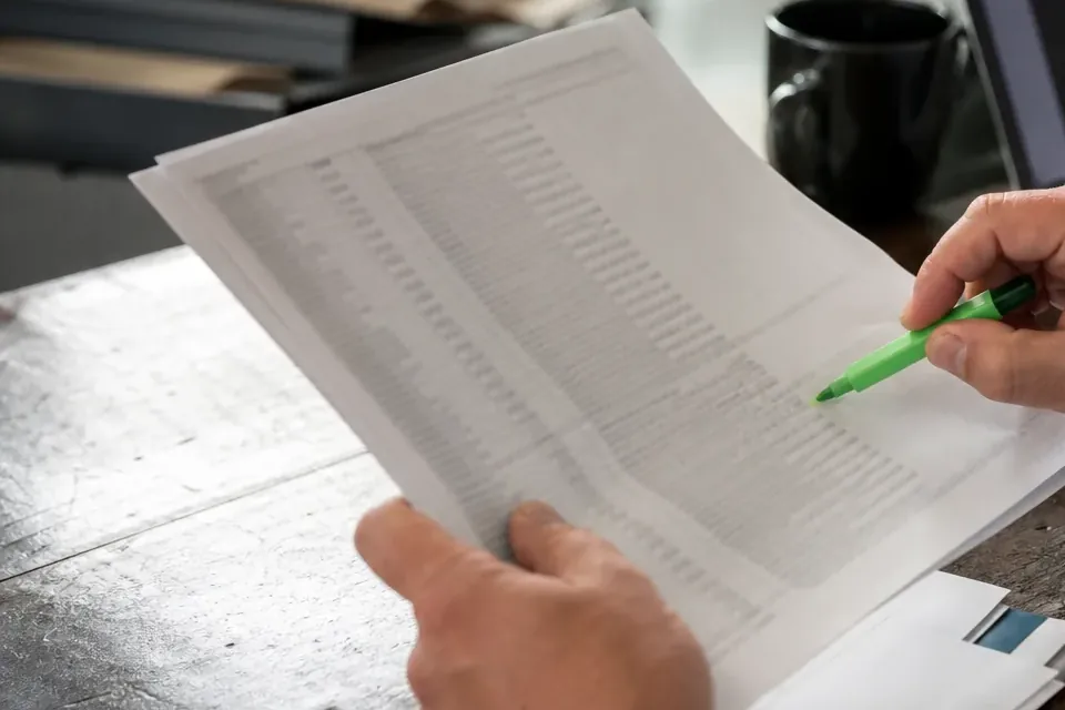 Wydruk odpisu z rejestru z zaznaczonym wierszem obok laptopa